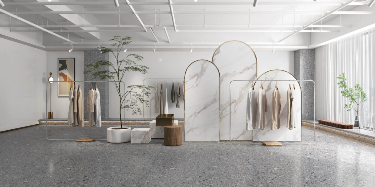 Minimalist clothing store interior with marble dividers and hanging garments.