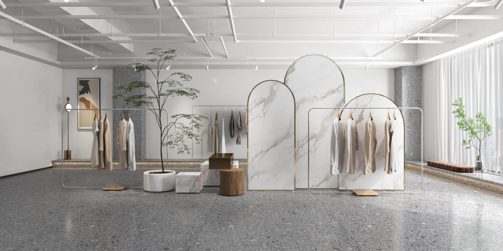 Minimalist clothing store interior with marble dividers and hanging garments.