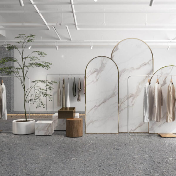 Minimalist clothing store interior with marble dividers and hanging garments.